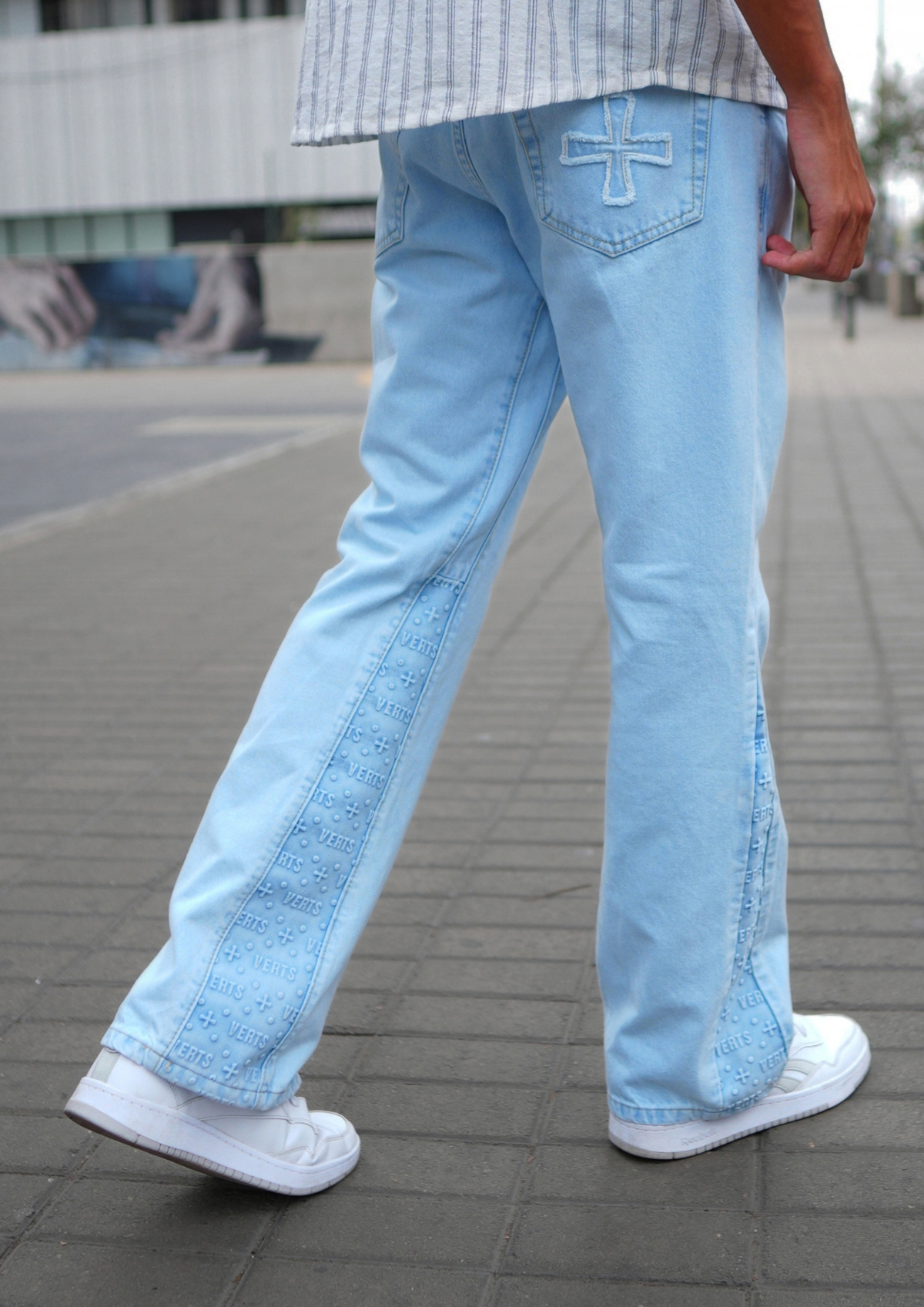 Model trägt Flared Jeans Ice, Rückansicht mit gesticktem Kreuz