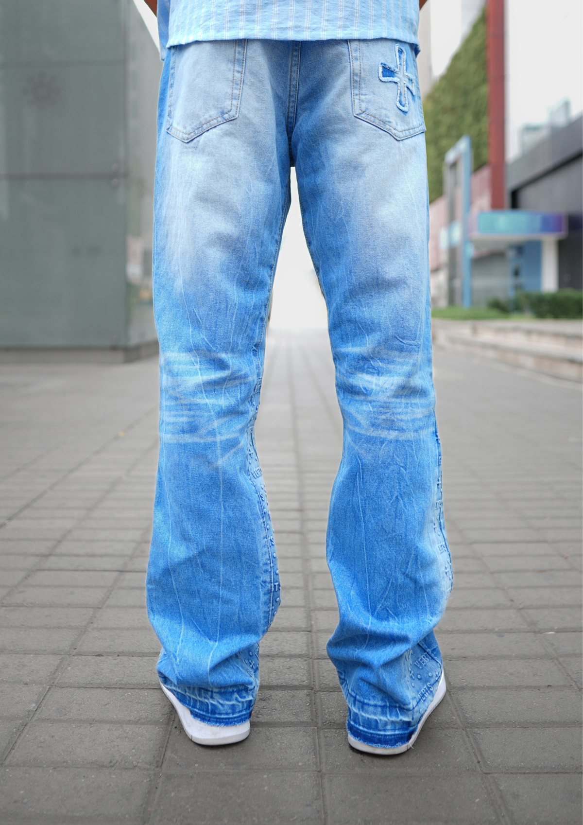 Model trägt Flared Jeans Sky, Rückansicht mit gesticktem Kreuz